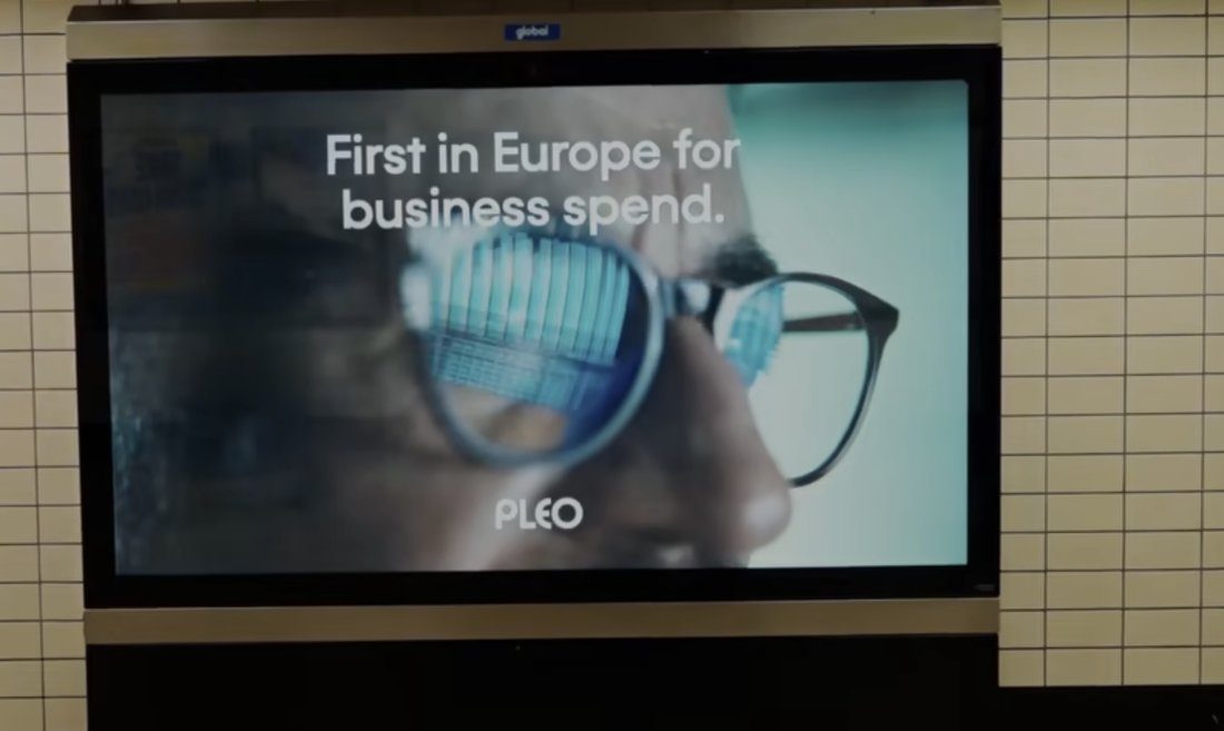Pleo advert on a London Underground platform screen showing glasses reflecting a city skyline.
